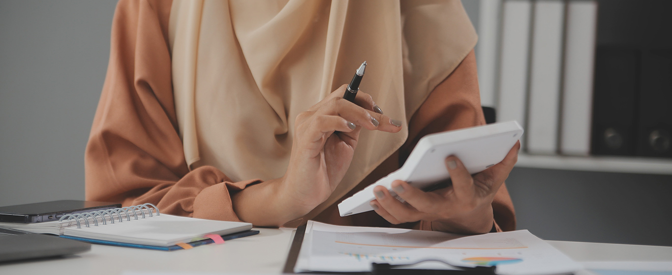 wanita muslim menghitung dengan kalkulator putih