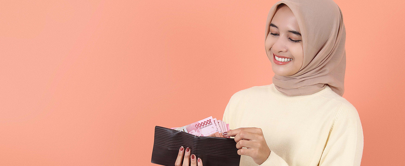 wanita muslim tersenyum mengambil uang dari dompet